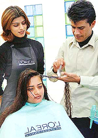 Creative Training Manager of L� Oreal Mel Roy treats the hair of a city resident on Tuesday.