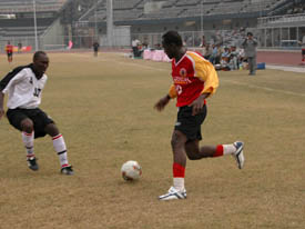 East Bengal striker Mike Okoro is challenged by Musa Aliu of JCT in the National Football League