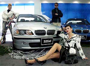 Models pose with BMW's new 325xi car during its Press unveiling in Seoul 