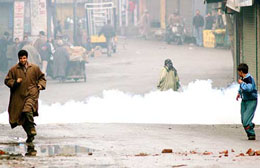 A protester runs for cover after the police used tear-gas shells to disperse a procession taken out by Kashmiri separatist parties in Srinagar on Wednesday.