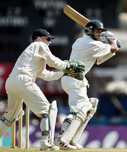 Sri Lankan batsman Tillakaratne Dilshan hits a boundary through the off side as England wicketkeeper Chris Read looks on