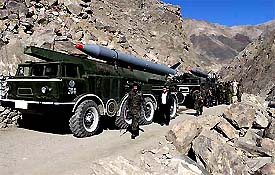 Afghan Defense Ministry troops walk past trucks carrying missiles along a road in Afghanistan's Panjsher valley 