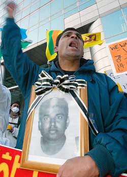Holding a portrait of Sri Lanka's Tharaka De Silwa who killed himself to avoid forced repatriation last month, a foreign worker shouts slogans during a rally against forced repatriation