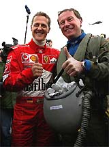 Formula One world champion Michael Schumacher gives a thumbs up with Eurofighter jet pilot Michele Cheli 