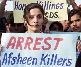 A human rights activist holds a placard at a rally against the killing of Afsheen Musarrat in Multan.