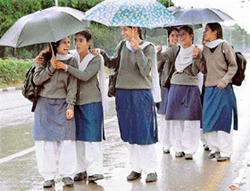 School girls take cover as widespread rain lashes Chandigarh on Monday.