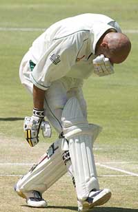 South Africa's Herschelle Gibbs holds his face after being hit by a Vasbert Drakes delivery