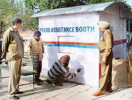 Police personnel get an advertisement removed from a beat box