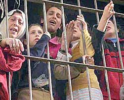 Palestinians cry as they watch paramedics carry the bodies of four Palestinian militants, killed by Israeli troops, at the West Bank city of Nablus