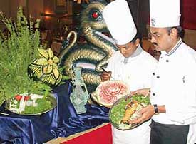 Chef Neeraj Chaudhry serves lobster against the backdrop of a stage set for the Oriental Food Festival at Maya Palace, Sector 35