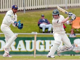 Micheal Clark cuts Murali Karthik for a boundary as wicketkeeper Parthiv Patel looks on