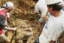 Rescue workers uncover bodies after deadly landslides swept through an area near Liloan town at the southern Leyte province of southern Philippines on Saturday