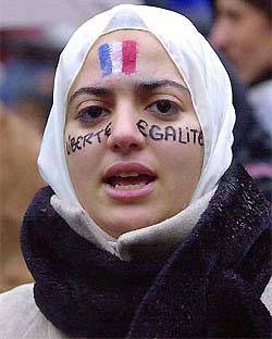 A girl wearing her head scarf, with the French flag and ��liberty, equality�� painted on her face, chants slogans as about 1000 persons demonstrated in Paris on Sunday