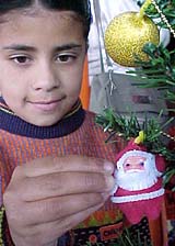 A girl looks at a Christmas Tree at a gift shop in Shimla 