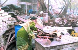 A woman rummages through the debris of her house, which was demolished by the MCD in Okhla Phase II in the Capital