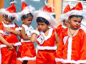 Children dressed as Santa Claus participate at a function to celebrate Christmas