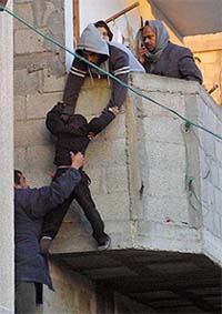 Palestinians evacuate a boy from his family home during an Israeli operation at Rafah refugee camp in the southern Gaza Strip 