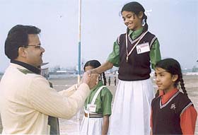 Girls receive medals from Mr Parveen Aggarwal during the annual sports meet of the Darshan Academy in Ludhiana