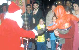 Santa Claus distributing sweets to children at Connaught Place in the Capital on Wednesday.