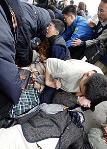 South Korean policemen try to arrest protesters during an anti-war rally at the National Assembly in Seoul