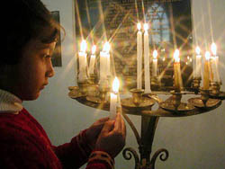 A child lights candles on the occasion of Christmas at the Catholic Church in Shimla on Thursday.