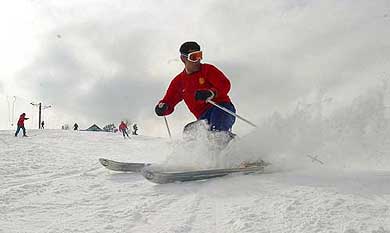 An Indian tourist enjoys skiing at Gulmarg