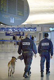 French security policemen with a sniffer dog patrol near an Air France check-in counter at Roissy Airport north of Paris