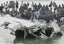 Rescue workers battle high waves to free bodies from the wreckage of an airliner in Benin on Friday. 