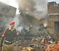 A military official stands guard near a fireworks explosion which killed at least five and injured several in Rawalpindi, 15 km south of Islamabad, on Saturday