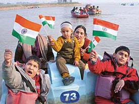 Children hold National Flags to celebrate the 118th anniversary of the Indian National Congress