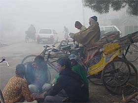 Rickshaw-pullers wait for business even as dense fog and extreme cold forced people to stay indoors in Ludhiana