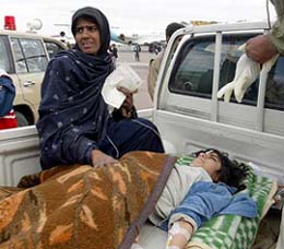 A mother takes care of her injured child at the airport in the southern Iranian city of Bam before being flown out