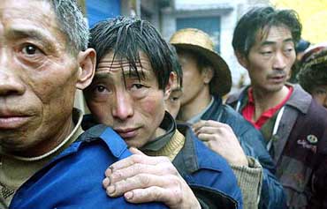 Chinese refugees of a natural gas blow-out line up to receive food at a refugee centre 