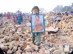 Five-year-old Pinki carries her precious belonging after her house was demolished by the municipal corporation at Dhandari Khurd in Ludhiana on Tuesday.