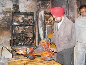 Tejinder Singh looks at charred goods after a fire broke out in his house in Sector 47, Chandigarh