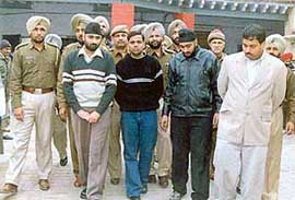 The four accused of murdering the cloth merchant are escorted out of Sadar police station in Ludhiana on Friday. The main accused, Avtar Singh, is in a black sweater. 