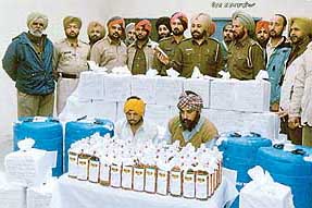 Alleged liquor smugglers Puran Singh and Makhan Singh are produced before mediapersons with the seized liquor that was being brought into Ludhiana from Chandigarh.