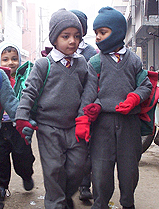 Schoolchildren arm themselves with extra woollens on the first day of school after the winter vacations