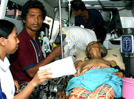 A man waits with his injured after an earthquake struck Karangasem on the resort island of Bali and neighbouring Lombok on Friday