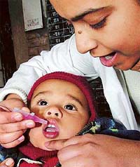 A volunteer administers polio drops to a child in Chandigarh