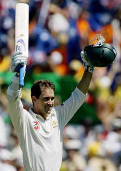 Australian batsman Justin Langer celebrates after completing his century