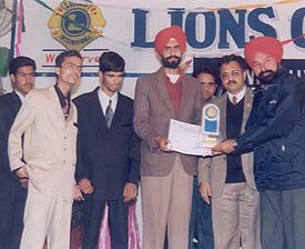 Members of the Visually Impaired Sports and Welfare Association honour Mr Ashok Garcha, president of the Improvement Trust