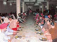 Devotees have langar on the occasion of Gurpurb at Gurdwara Kalgidhar, Fied Gunj