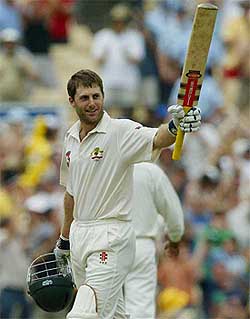 Australian batsman Simon Katich waves his bat in celebration after scoring his maiden Test century 