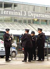 Armed British police officers stand on duty at Heathrow Airport