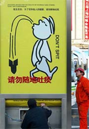 Chinese workers install a billboard urging people to stop spitting as local authorities try to fend off a possible return of SARS in Shanghai