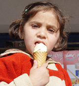 A child enjoys an ice-cream on a bright and sunny morning in Ambala on Tuesday