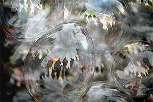 Tourists are reflected in a street vendor's bubbles near Gateway of India in Mumbai 