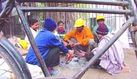 Roadside workers huddle around a bonfire in the Capital 
