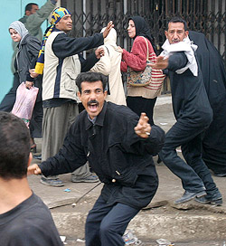People run for cover after a protest by former Iraqi soldiers turned violent in the southern Iraq city of Basra.